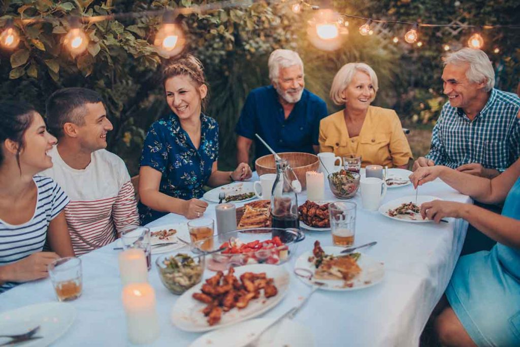 Family laughing and enjoying a dinner outside. 