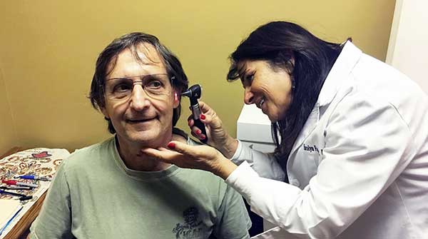 Harolyn Farber, MS, NBC-HIS
checking a clients ear with an otoscope. 